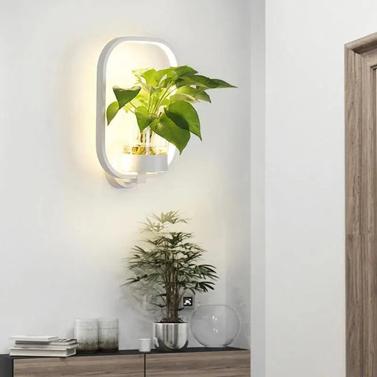 Moderne wandlamp met een unieke plantenhouder, perfect voor het combineren van groen en verlichting.