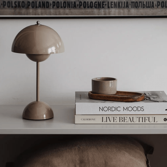 Pieter stijlvolle retro tafellamp op een elegant ingerichte tafel met boeken en schrijfgerei.