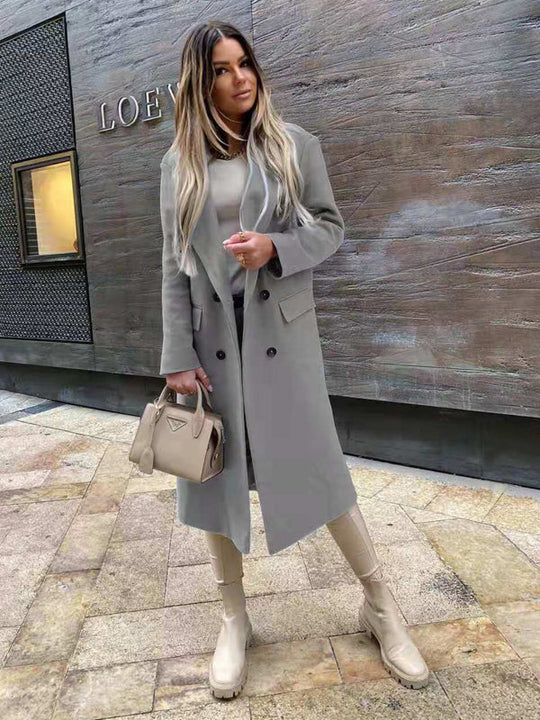 Elise's Dames Klassieke Lange Jas Winterjas, perfect voor een klassieke en verfijnde look tijdens koude dagen. De jas heeft een stijlvolle snit met dubbele knopen, gecombineerd met een modieuze handtas en hoge laarzen voor een complete winterse outfit. Ideaal voor zowel formele als casual gelegenheden waar comfort en klasse samenkomen.