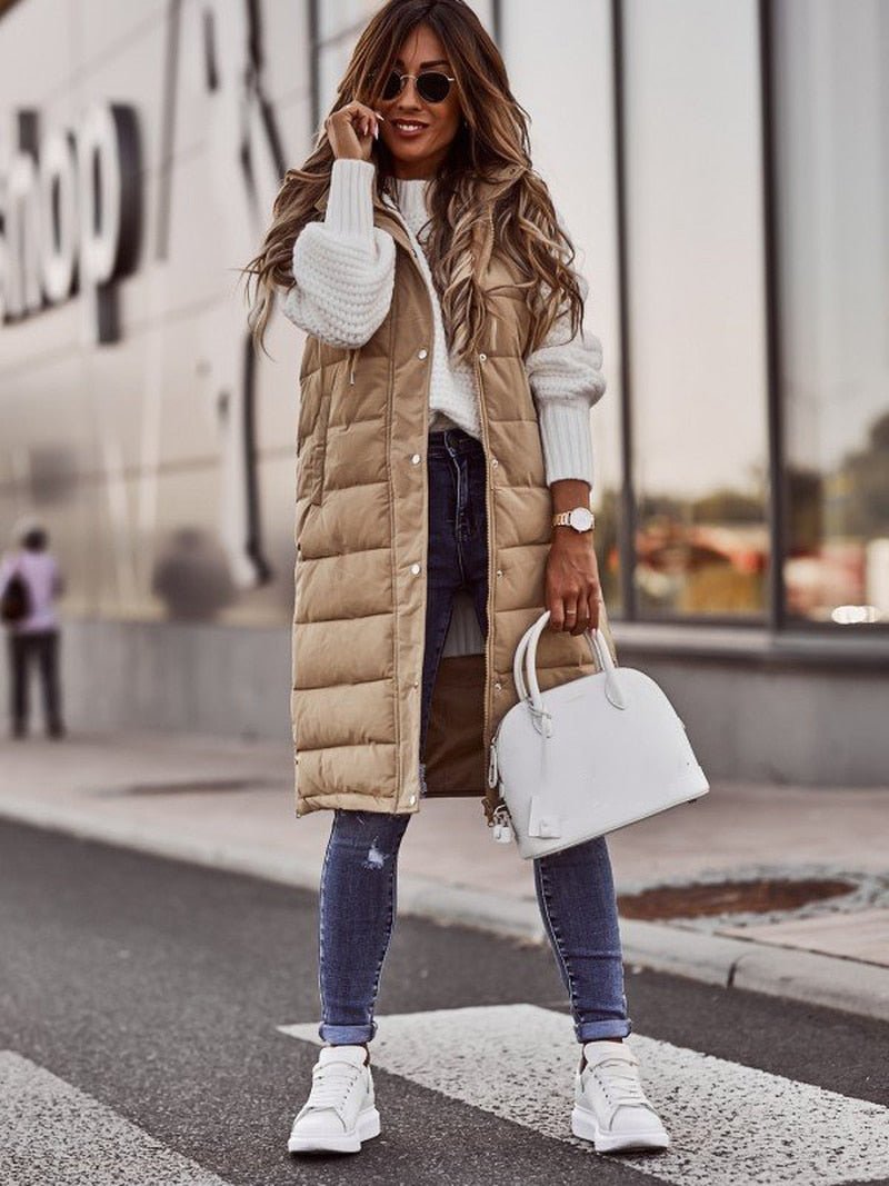 Vrouw draagt een lange dames bodywarmer met capuchon, ideaal voor een modieuze en warme look.